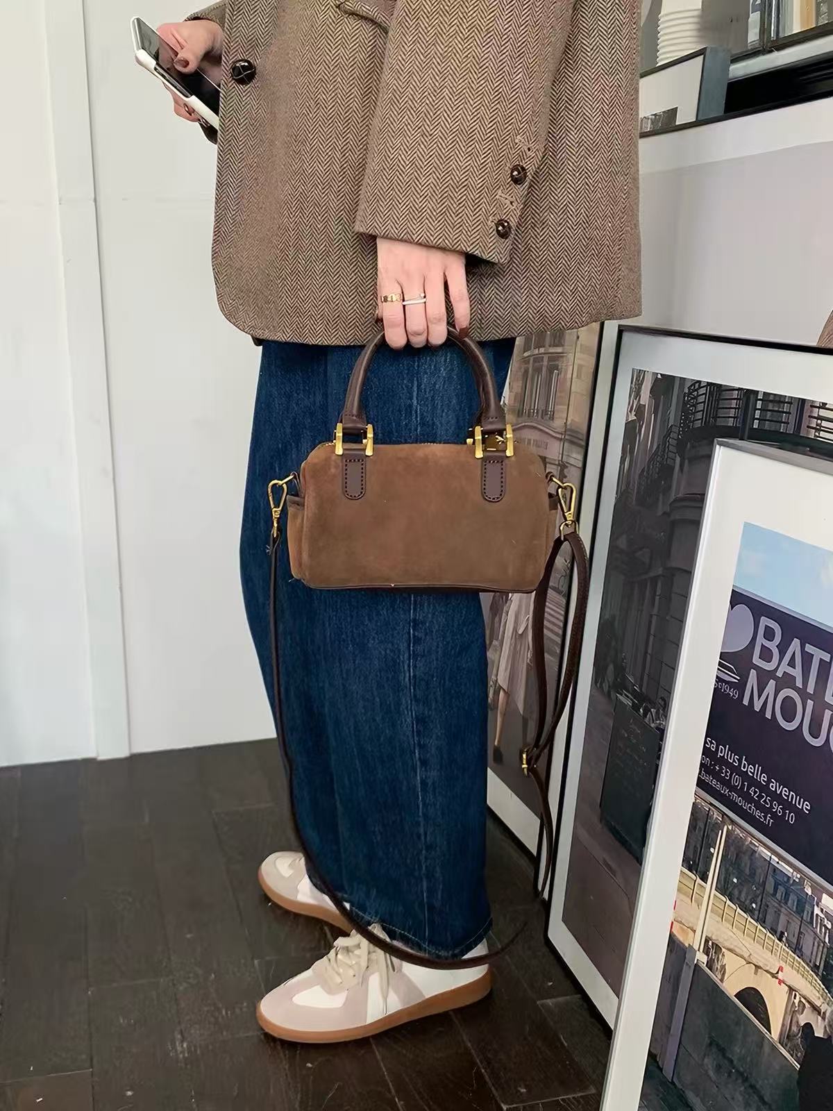 Marnie brown top-handle mini bag carried by hand