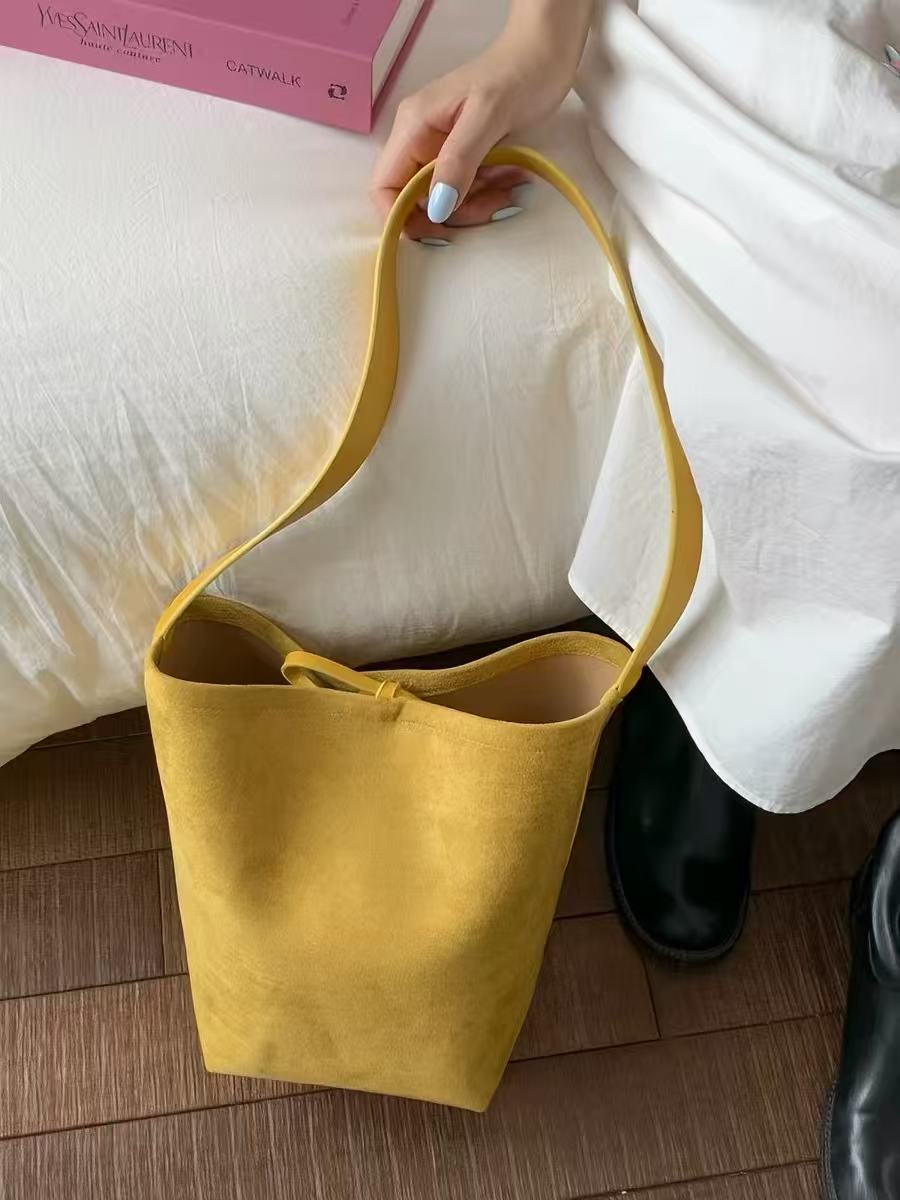 Saffron mustard bucket bag showing its top opening and tie details