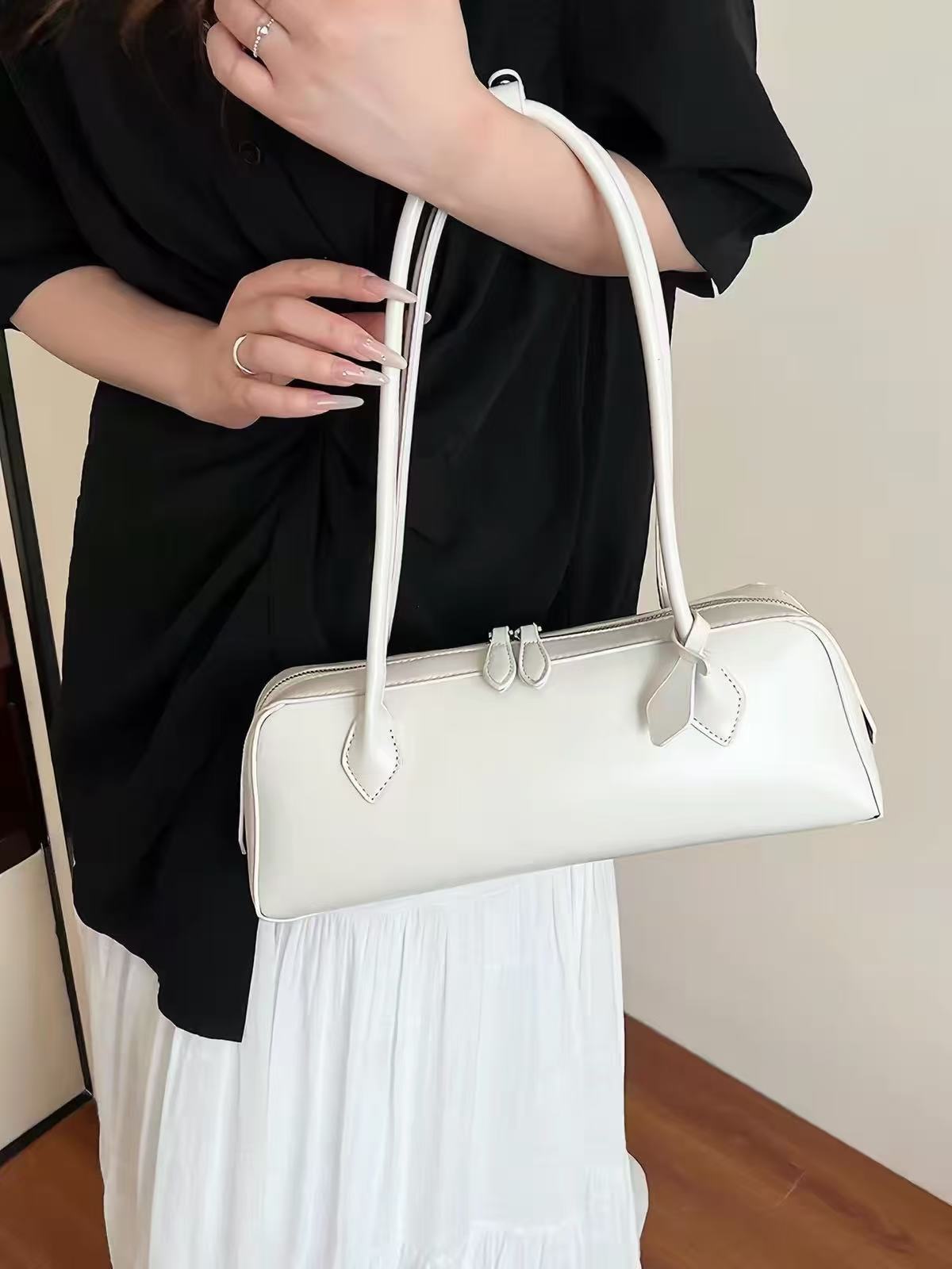 Solenne ivory shoulder bag showing long straps and stitched edges